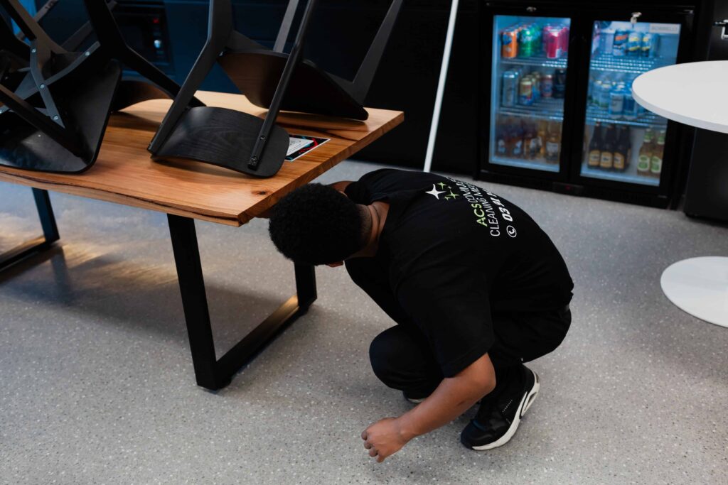 Cleaner cleans office tables after consulting office cleaning checklist